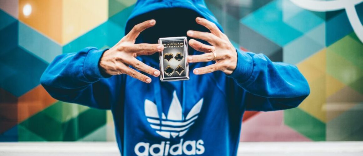 man in blue adidas hoodie doing magic trick